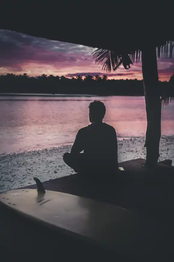 silhouette-lonely-person-sitting-by-sea-enjoying-beautiful-view-sunset